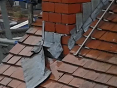 Lead flashing fitted around a repointed brick chimney stack