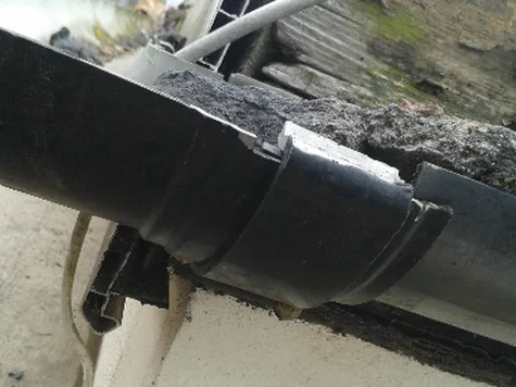A damaged cast iron gutter and downpipe needing replacement