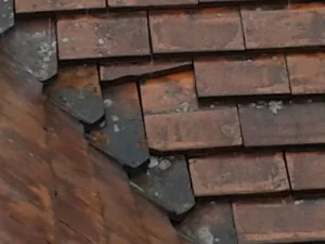 Slipped and broken clay roof tiles in need of repair